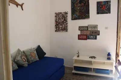 a living room with a blue couch and a table at Al Baglio low cost in Palermo
