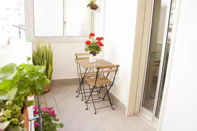 a small balcony with a table with flowers on it at B&B d'Orleans in Palermo