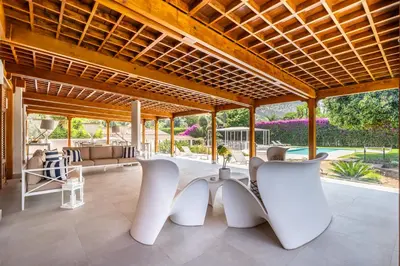 an outdoor living room with white chairs and a wooden ceiling at Il Giardino di Venere in Mondello
