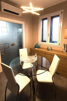 a dining room with a glass table and white chairs at ZE-VI HOME in Santa Flavia