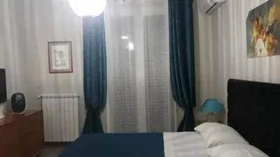 a bedroom with a bed with blue drapes at ZE-VI HOME in Santa Flavia