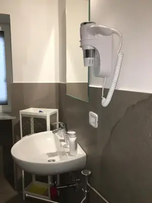 a bathroom with a sink and a hair dryer on the wall at Like Home Palermo in Palermo
