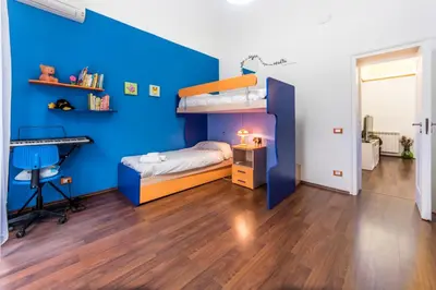 a blue room with a bunk bed and a desk at Casa Valire in Palermo