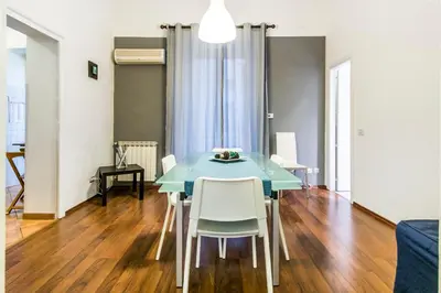 a dining room with a blue table and white chairs at Casa Valire in Palermo
