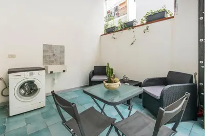 a small apartment with a table and chairs and a washing machine at Casa Valire in Palermo