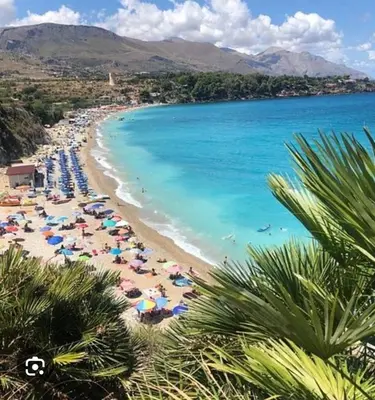 a beach with umbrellas and people in the water at Appartamento 