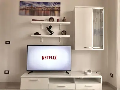 a living room with a television on a white entertainment center at Giù a Palermo in Palermo