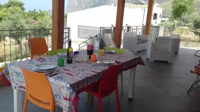 a table with chairs and a table cloth on a balcony at Villa Cloe in San Vito lo Capo
