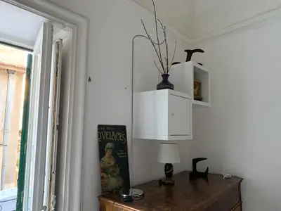 a room with a table with a lamp and a window at FraLePorte in Palermo