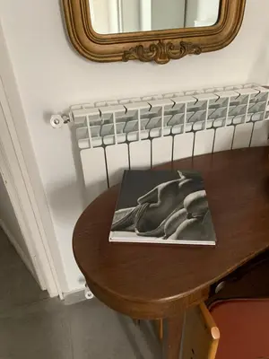 a book on a wooden table with a mirror at FraLePorte in Palermo