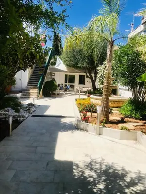 a walkway in front of a house with trees at Il Sole di Mondello in Mondello