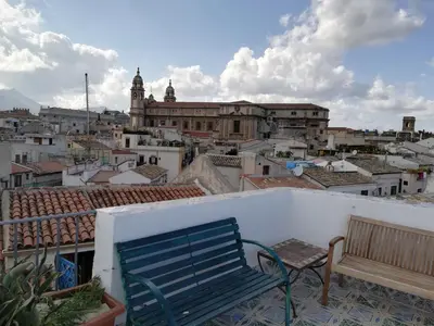 a blue bench sitting on a balcony looking at a city at Casa in palazzo Graffeo Sven in Palermo