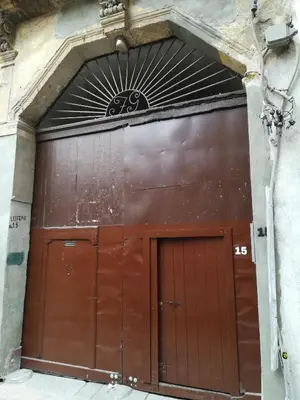 a large brown garage door with a sign above it at Casa in palazzo Graffeo Sven in Palermo