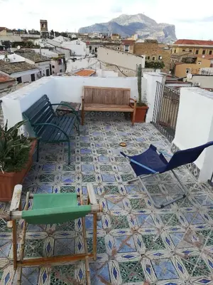 a patio with chairs and a bench on a tile floor at Casa in palazzo Graffeo Sven in Palermo