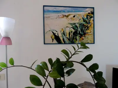 a living room with a tv and paintings on the wall at Villa Flore in Casteldaccia