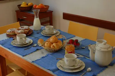 a table with cups and plates of food on it at Casa al Bragone in Termini Imerese