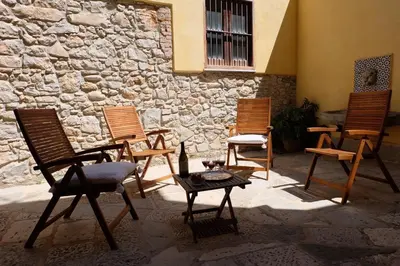 a group of chairs and a table in front of a stone wall at Casa al Bragone in Termini Imerese