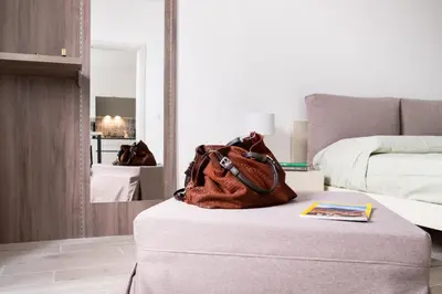 a purse sitting on top of a ottoman in a bedroom at Vasa Vasa Home in Palermo