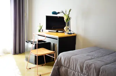 a bedroom with a desk with a television and a bed at B&B AL PASSIO in Palermo