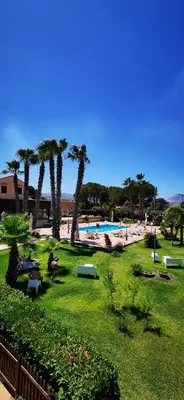 a park with palm trees and a swimming pool at Azienda Agrituristica Baglio Carta in Balestrate
