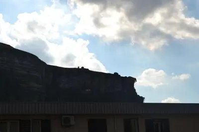 a building with a mountain in the background at Rua House in Corleone