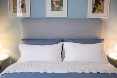a bed with two pillows and two pictures on the wall at Scirocco House in Palermo