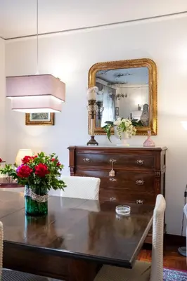 a dining room table with a mirror and a dresser at Scirocco House in Palermo