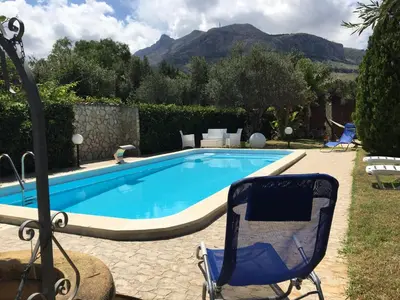 a blue chair sitting next to a swimming pool at Villino Giulia in Altavilla Milicia