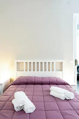 a bedroom with a purple bed with two towels on it at Il Tarì Apartment in Palermo