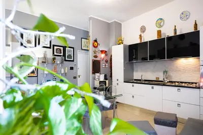 a living room with a kitchen with white cabinets at Hola Cathedral House in Palermo