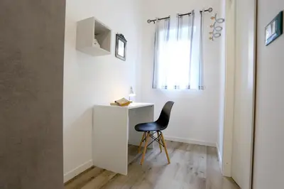 a chair sits next to a desk in a room at Sol&Luna 1909 in Palermo