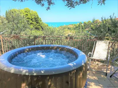 a large hot tub with blue water in a yard at Guidaloca Bay House con mini-piscina Scopello in Castellammare del Golfo