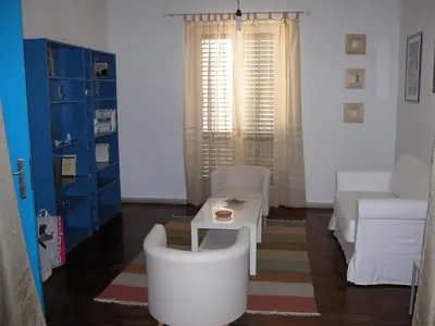 a living room with a couch and a table and chairs at La Caletta in Santa Flavia