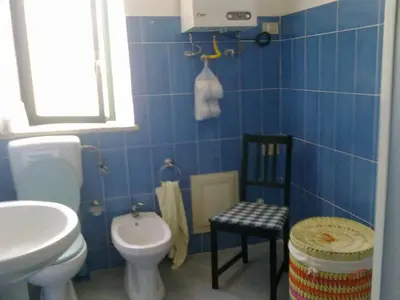 a blue bathroom with a toilet and a sink at La Caletta in Santa Flavia