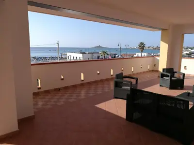 a balcony with chairs and a view of the beach at Casavacanze corallo in Isola delle Femmine