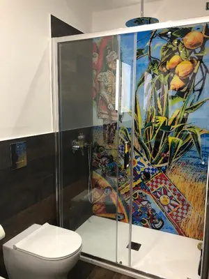 a bathroom with a shower with a toilet and a painting at COCCIU D’AMURI in Castellammare del Golfo