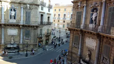 a group of people walking down a street in a city at Hostel Tribunale Room Basement in Palermo