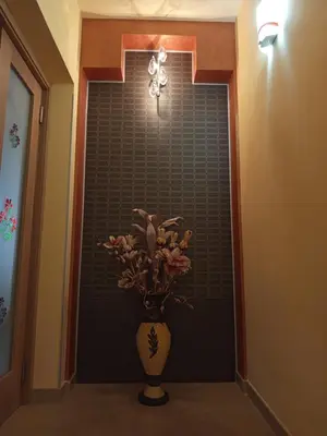 a vase with flowers in front of a wall at Amaryllis Hotel in San Vito lo Capo