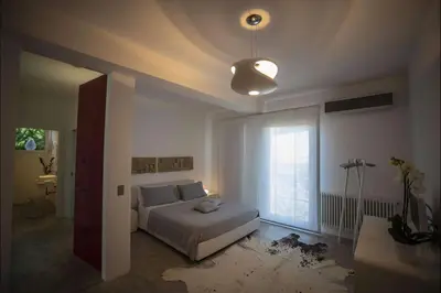 a bedroom with a bed and a large window at Villa Corallo in Cinisi