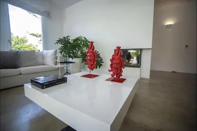 a living room with two red sculptures on a white table at Villa Corallo in Cinisi