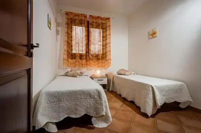 a bedroom with two beds and a window at Villa Thyrrenia in Castellammare del Golfo