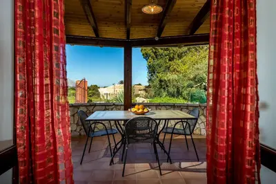 a table and chairs on a screened in porch at Villa Thyrrenia in Castellammare del Golfo