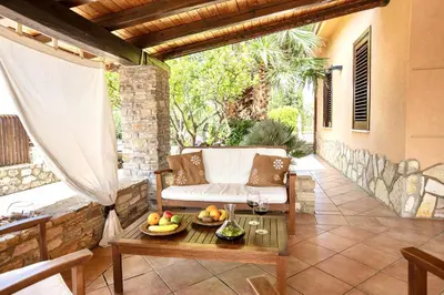 a patio with a couch and a table at Villa Isabella in Castellammare del Golfo