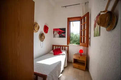 a small bedroom with a bed and a window at Villa La Randa in Castellammare del Golfo