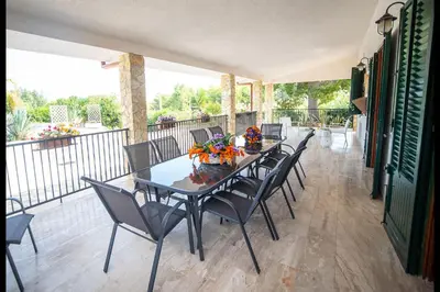 a dining room with a table and chairs on a balcony at Villa La Randa in Castellammare del Golfo