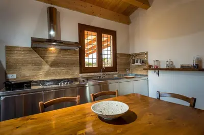 a kitchen with a wooden table and a sink at Villa Thalia in Castellammare del Golfo