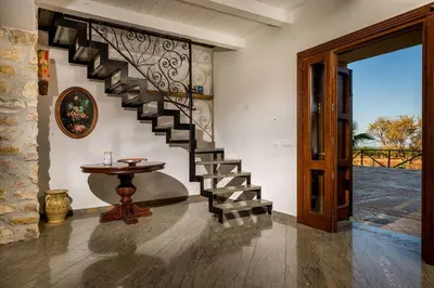 a staircase in a house with a table and a door at Villa Thalia in Castellammare del Golfo