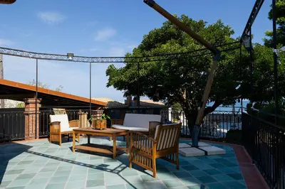 a patio with a table and chairs and a tree at VILLA ROSETTA ampi spazi esterni WIFI FREE in Trabia
