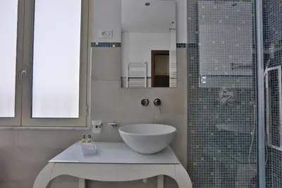 a bathroom with a sink and a glass shower at Residenza Wagner in Palermo