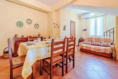 a dining room with a table and chairs and a bed at Villa Ficodindia in Altavilla Milicia